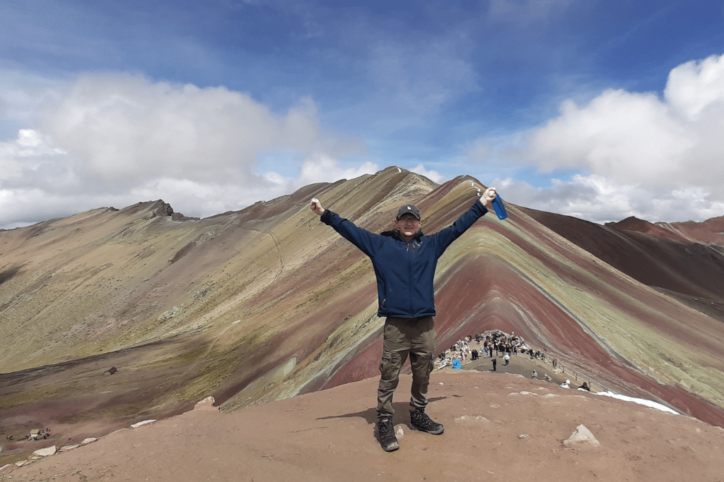 At the highest viewing point with Rainbow Mountain in the background. 
