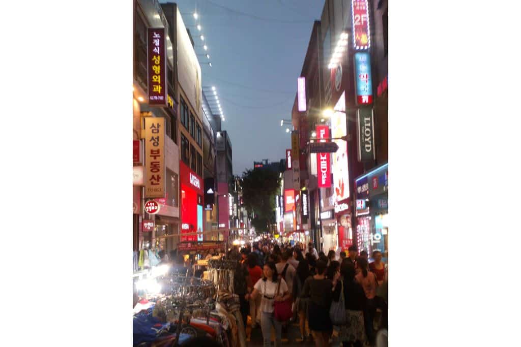 A busy Myeongdong high street at night.
